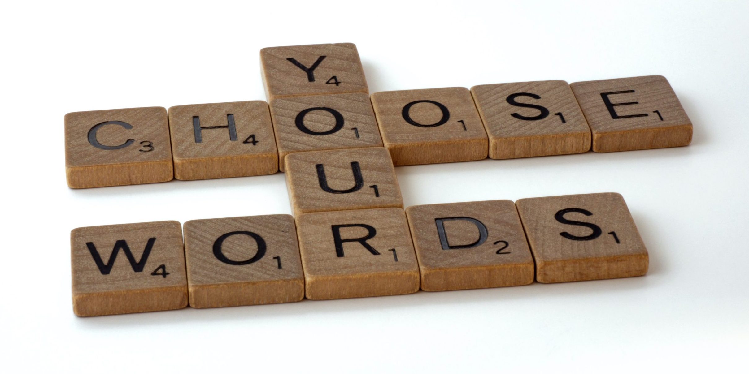Image of scrabble tiles forming the words Choose Your Words to illustrate how language creates power