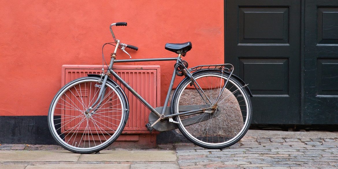 grey bike against a coral coloured wall