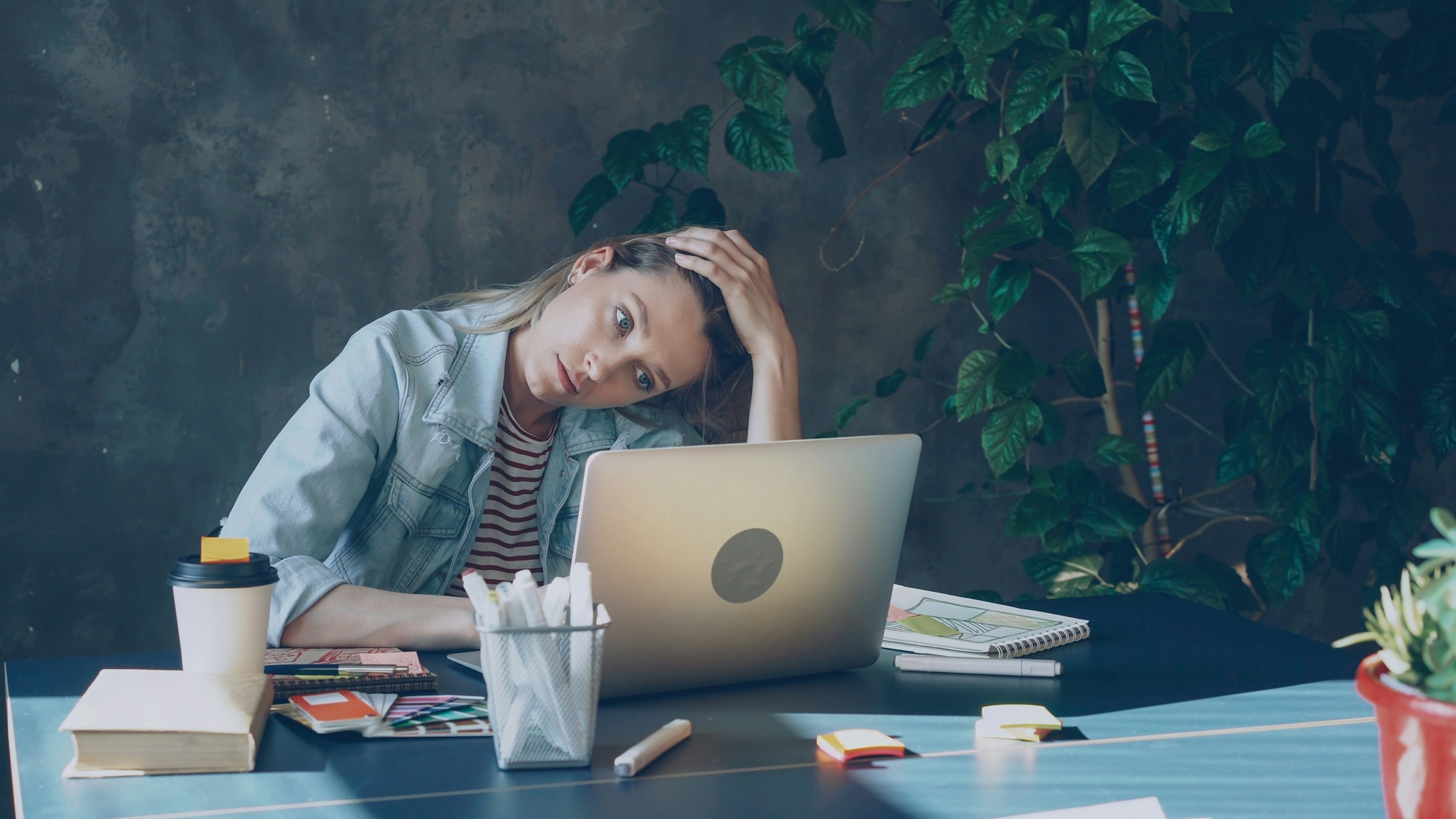 vitaly-gariev-AP7KmJXEVVI-unsplash reduced a woman in front of her laptop at a desk holds her head in her hand and looks worried signifying a lack of psychological safety